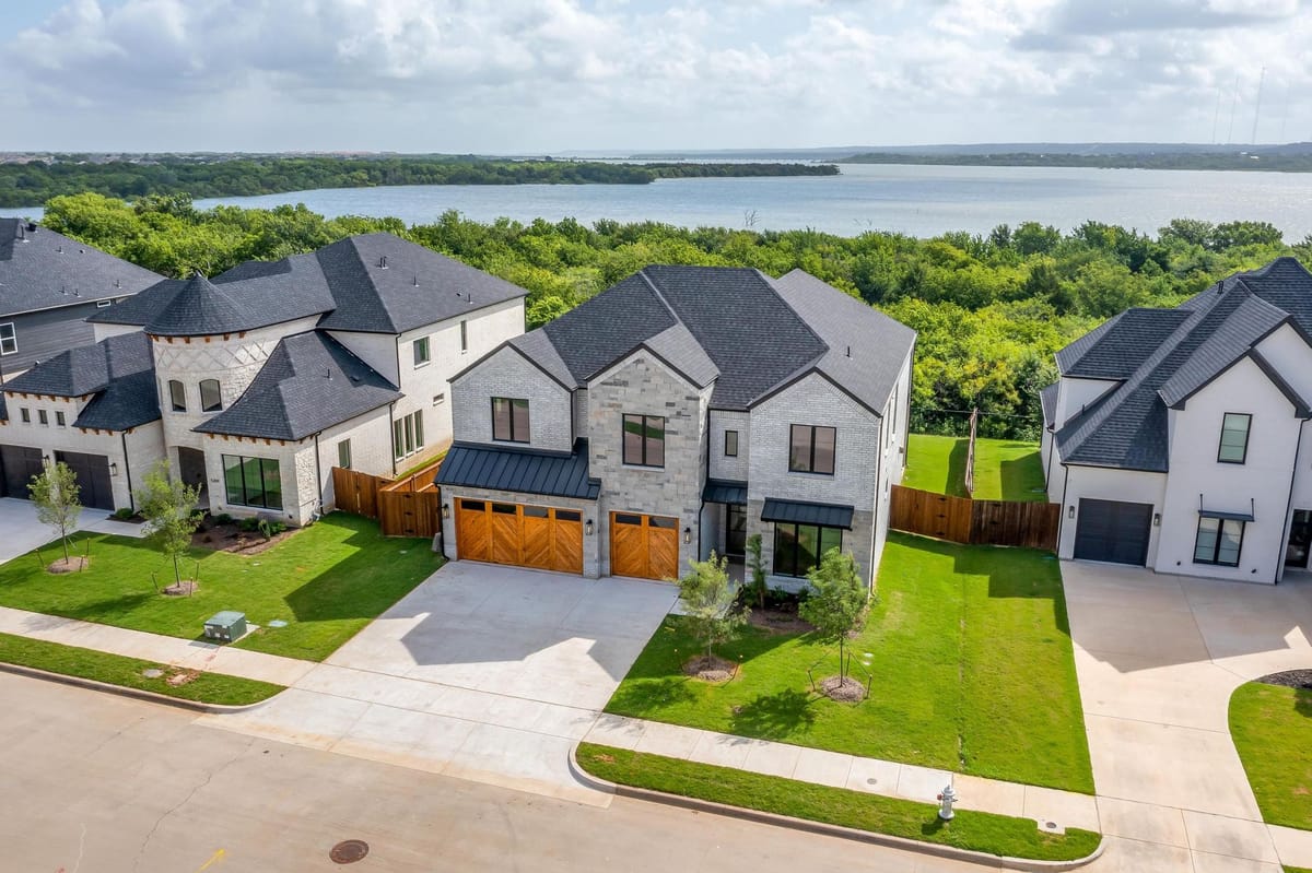 Aerial view of a street of completed Parkwood custom homes with a lake beyond