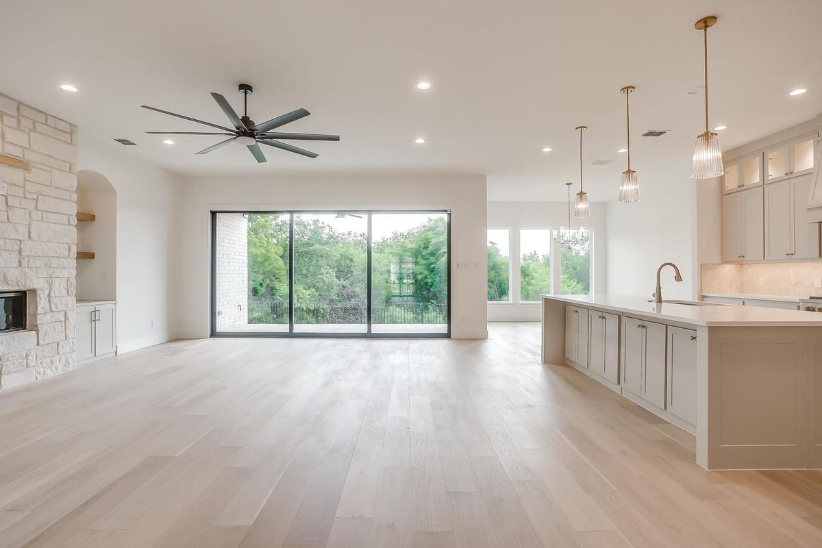 Open great room in a Parkwood custom home with a wall of windows looking onto the back yard