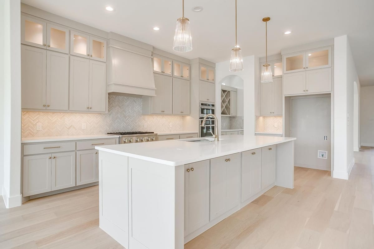 Kitchen with a large island, pendant lighting, and glass-front upper cabinets