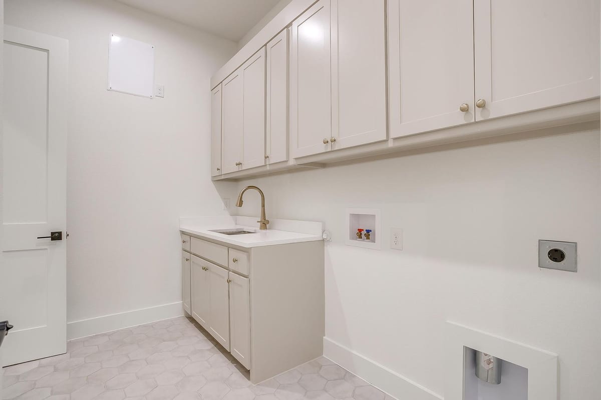 Utility room with cabinetry, a sink, and washer and dryer hookups