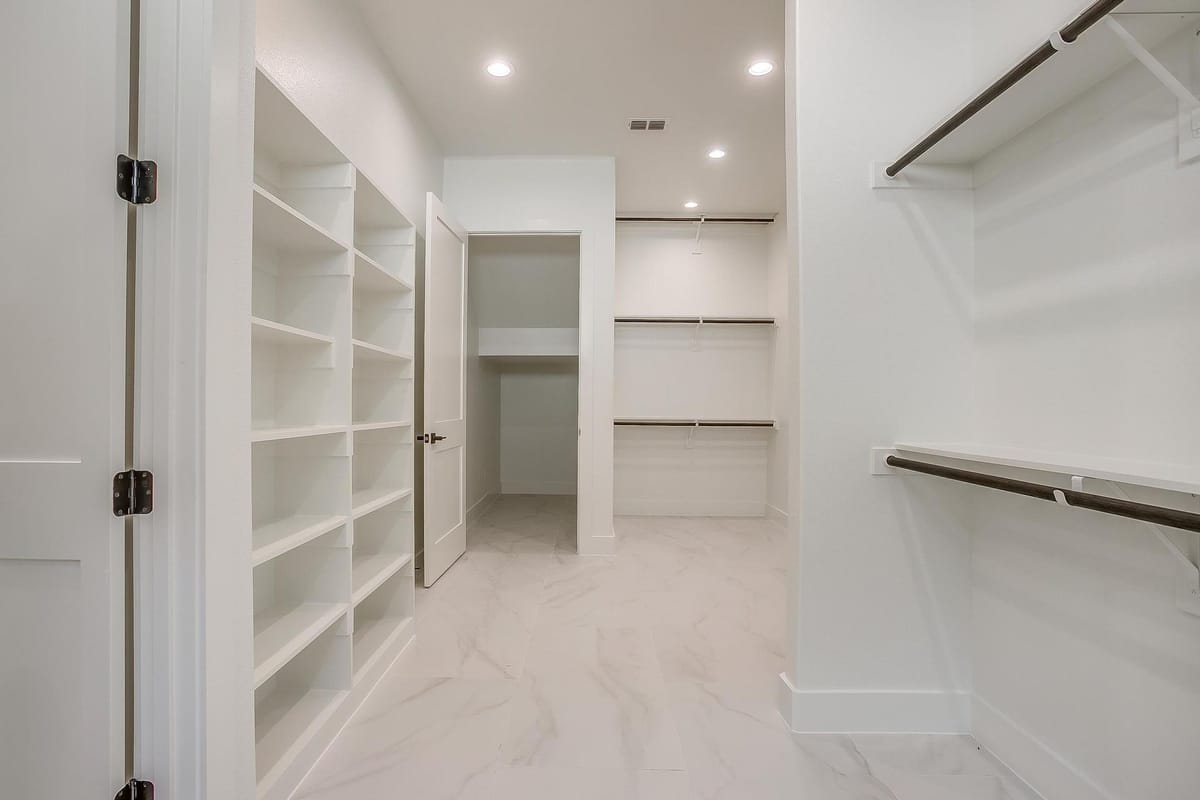 Walk-in closet with open shelving and hanging rods