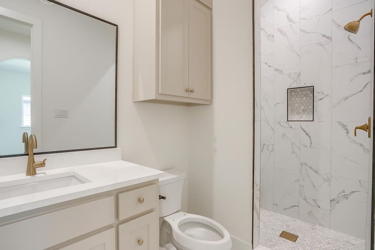 Bathroom with a marble tile shower and a floating vanity