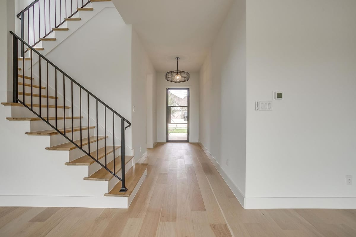 Entry hall looking toward the front door past an open stair