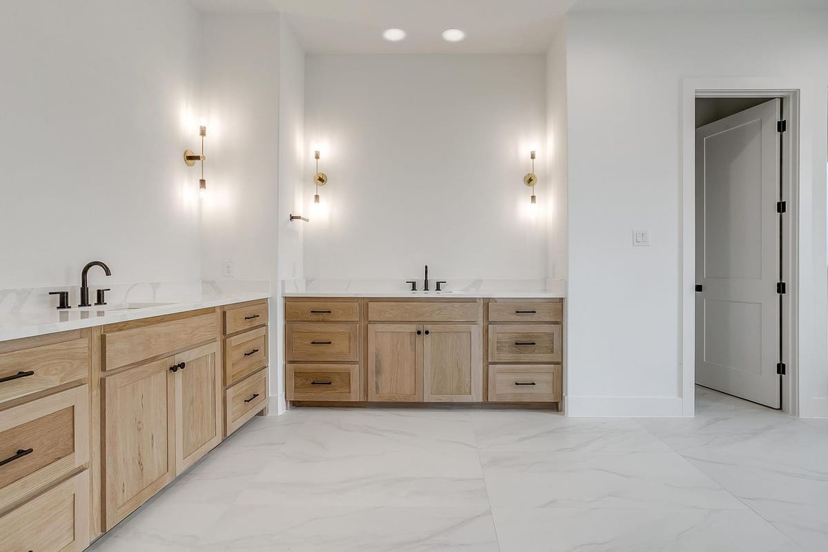 Double vanity with wood cabinetry and sconce lighting