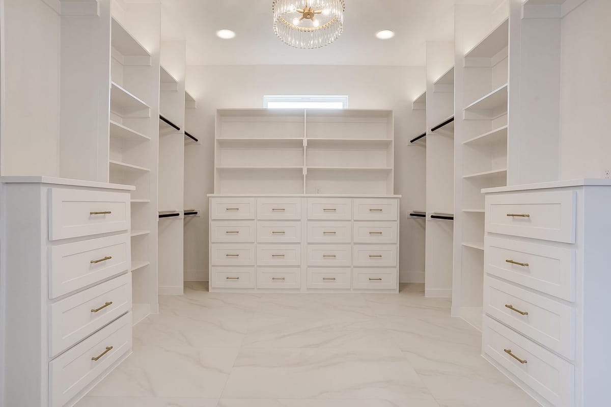 Walk-in closet with built-in drawers and hanging space on every wall