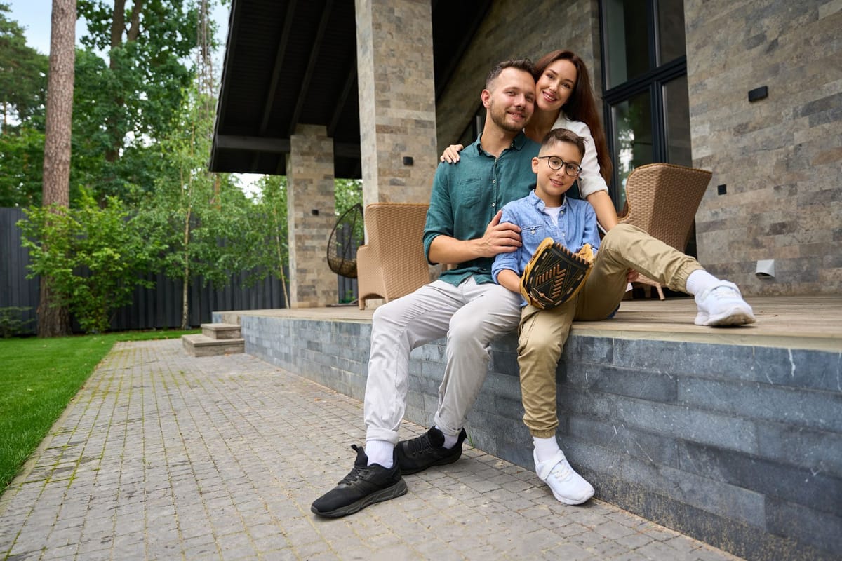 A family sitting together on the porch steps of a home